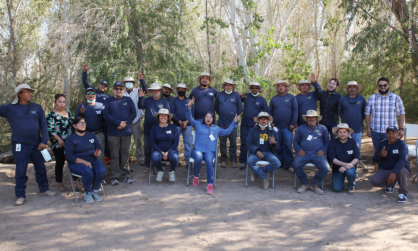 Equipo de Pronatura Noroeste con bosque de álamos de fondo