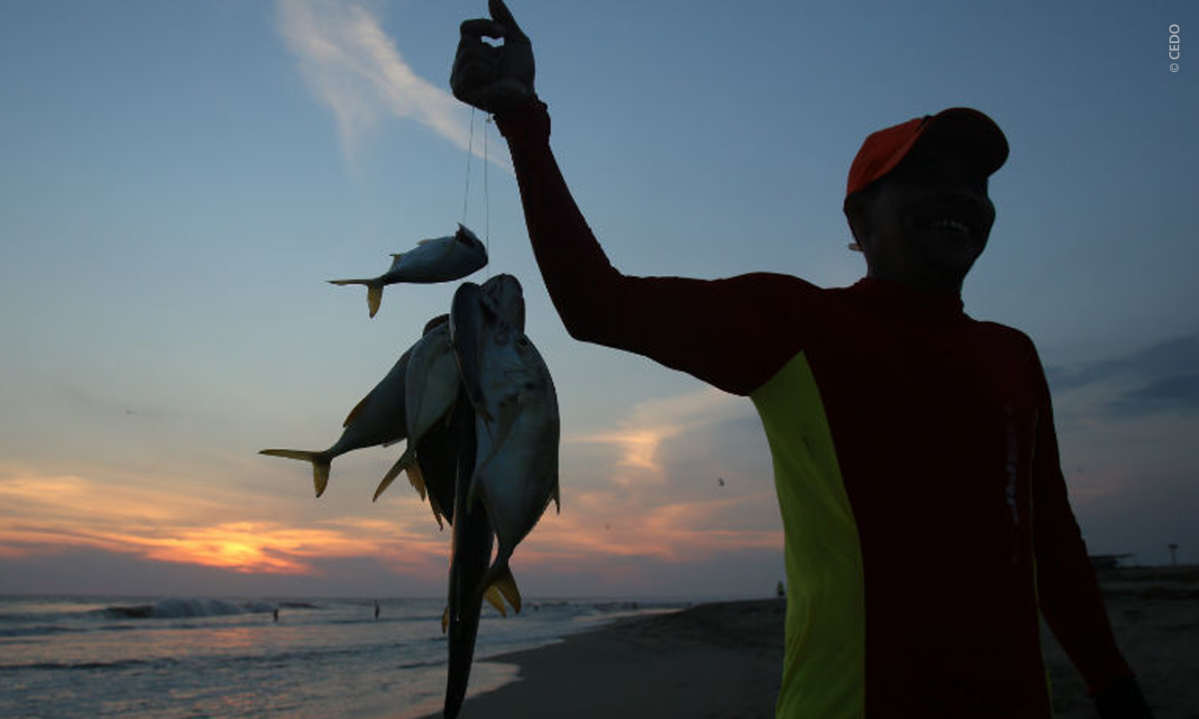 Fisherman holding fish at sunset in Sonora