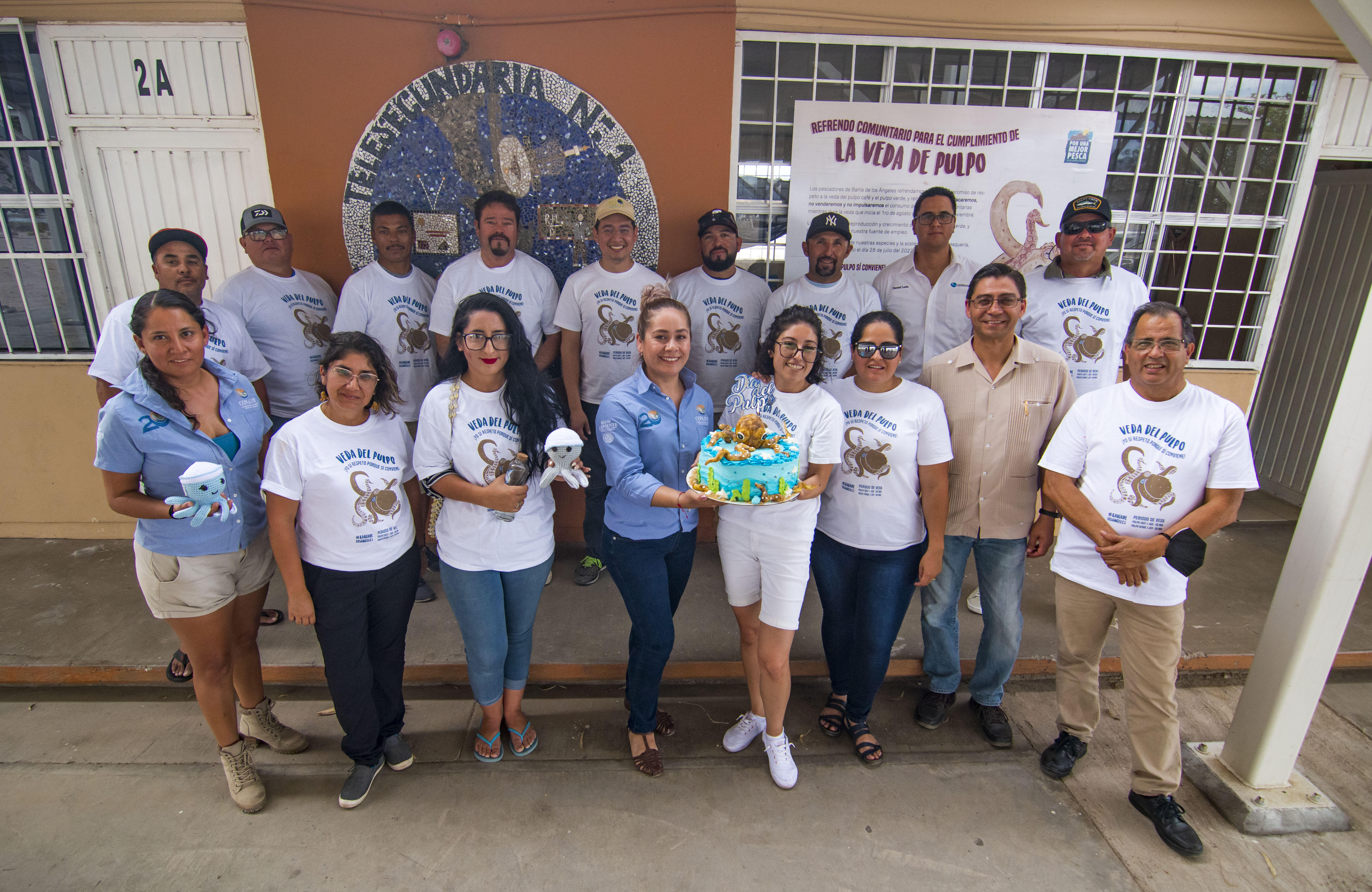 Grupo de personas frente a lona 