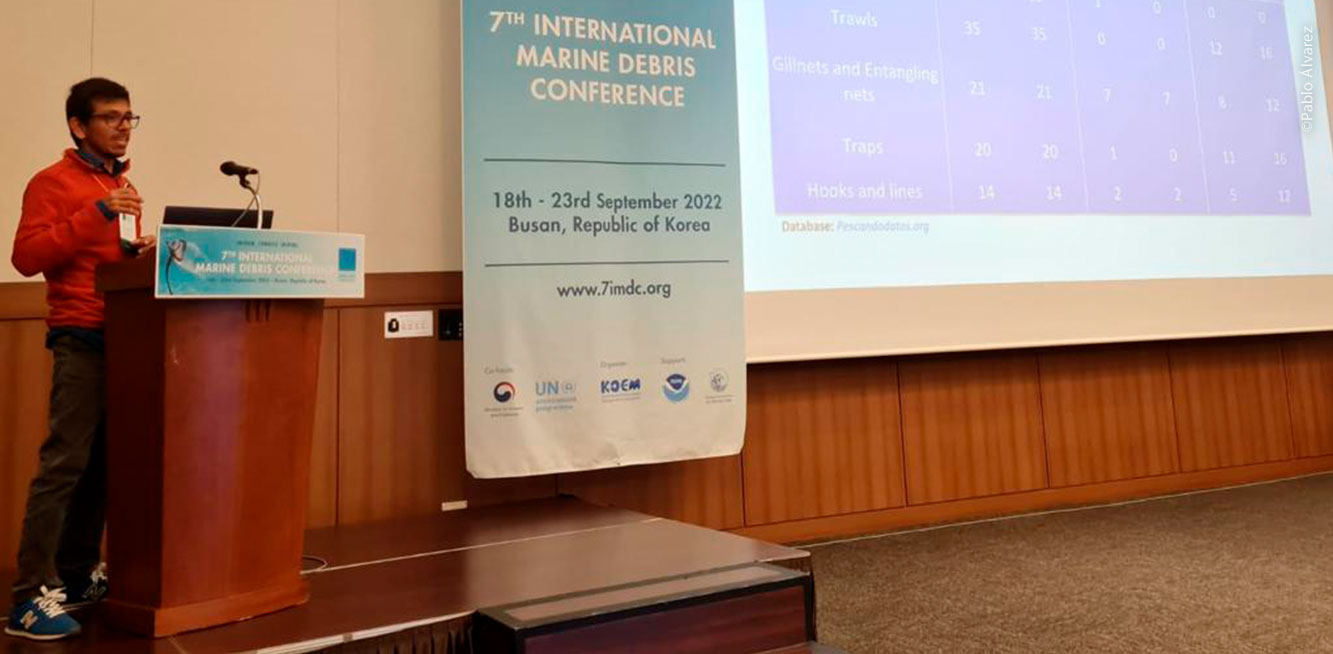 Pablo Álvarez hablando en público junto a un enorme banner que dice "7th International Marine Debris Conference"
