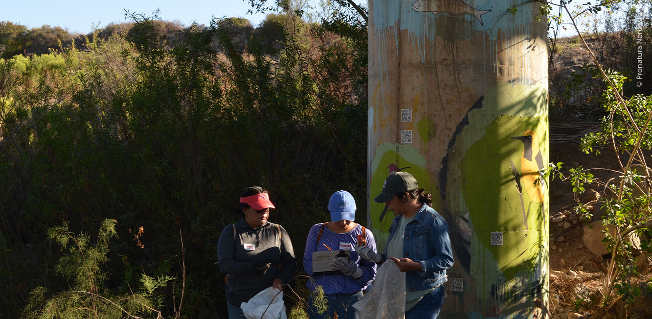 Personas haciendo registro de la recolección de residuos debajo del puente San Miguel